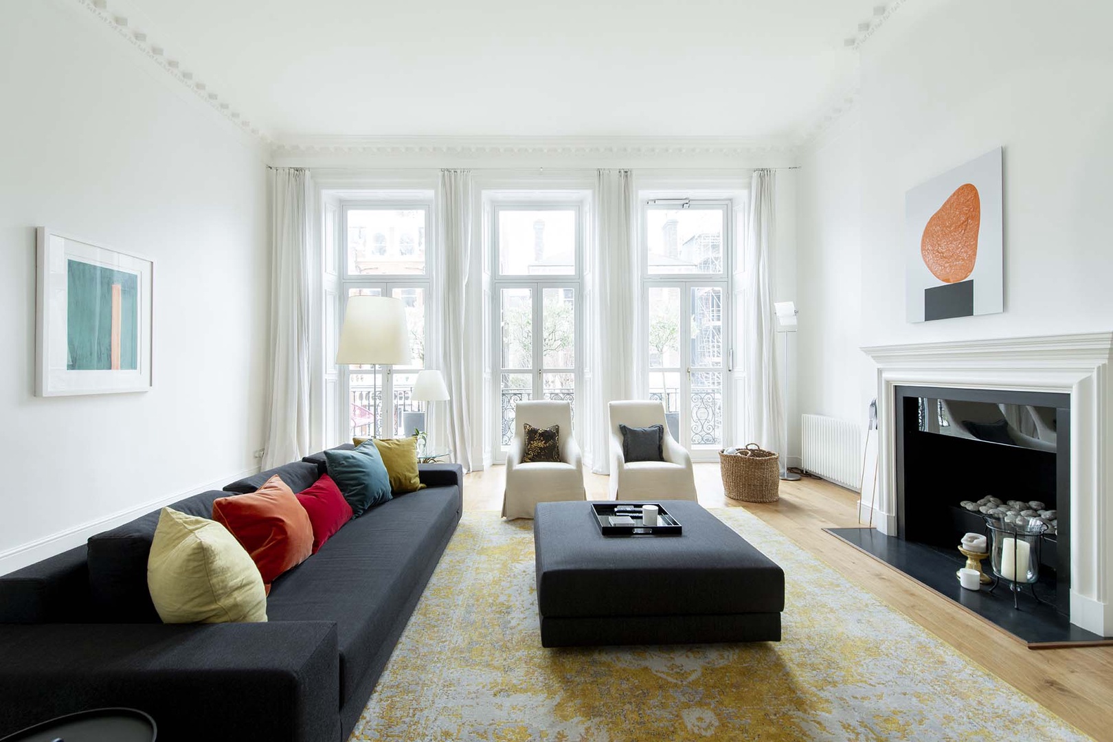 The modern living room has three large doors that open to a charming balcony.