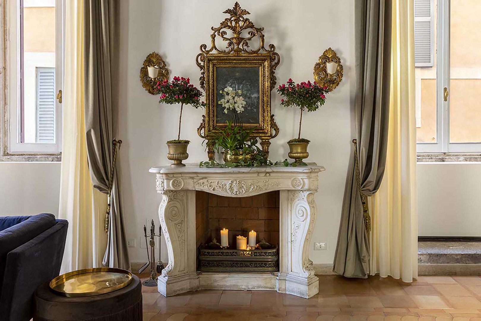 The fireplace and antique painting form a charming backdrop.