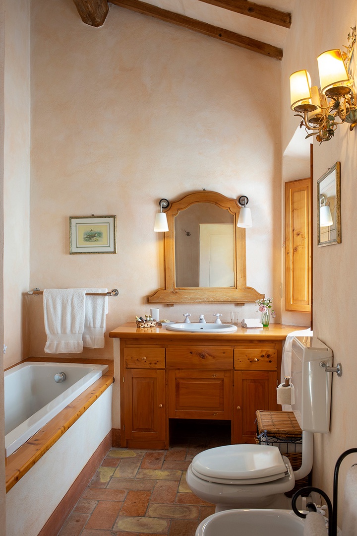 Bathroom with both a tub and shower, sink, toilet and bidet.