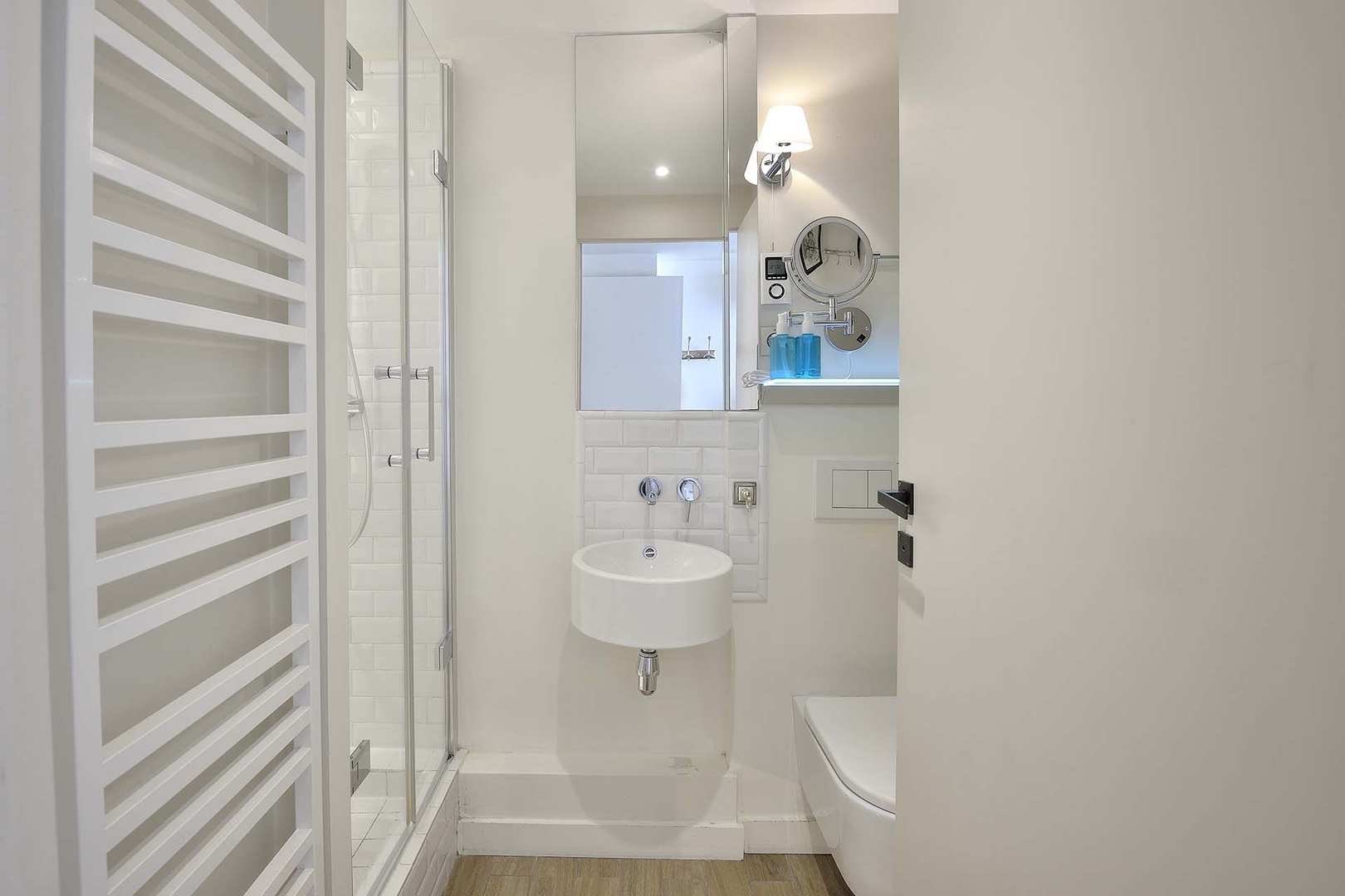The bathroom has a shower, sink and toilet.