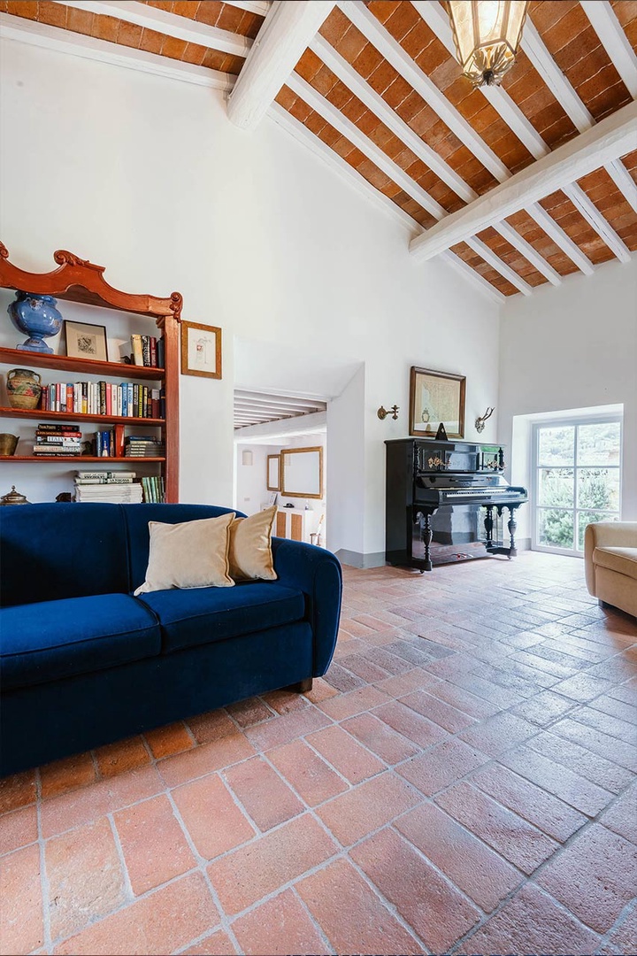 Cottage living room complete with fireplace and piano.