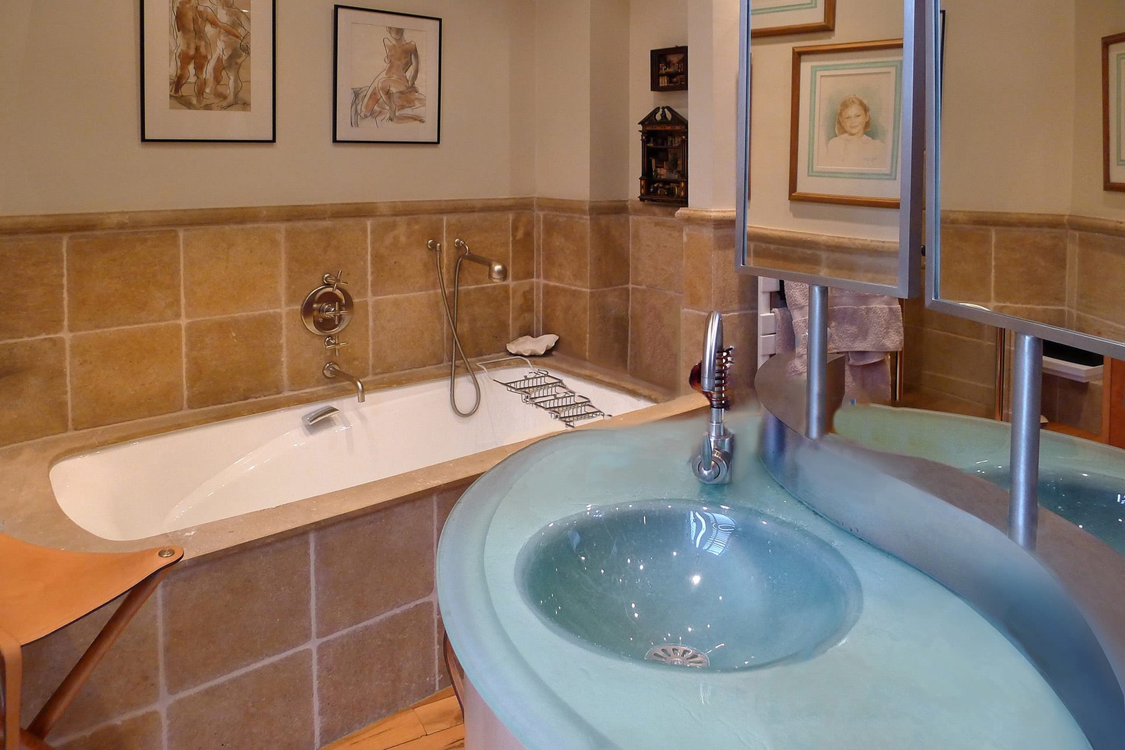 The bathroom features unique circular back-to-back glass sinks.