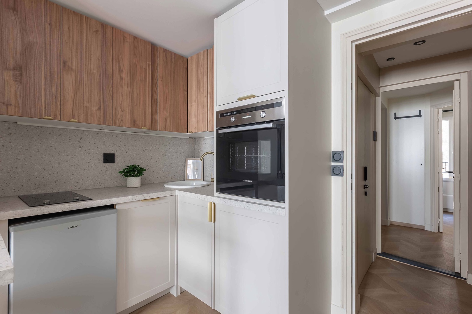 Compact kitchen has dishwasher and washer/ dryer combo.