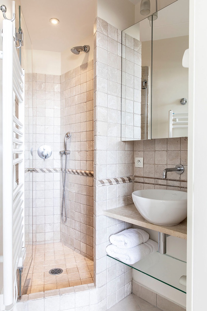 Bathroom with shower and sink. Toilet in a separate room for convenience.