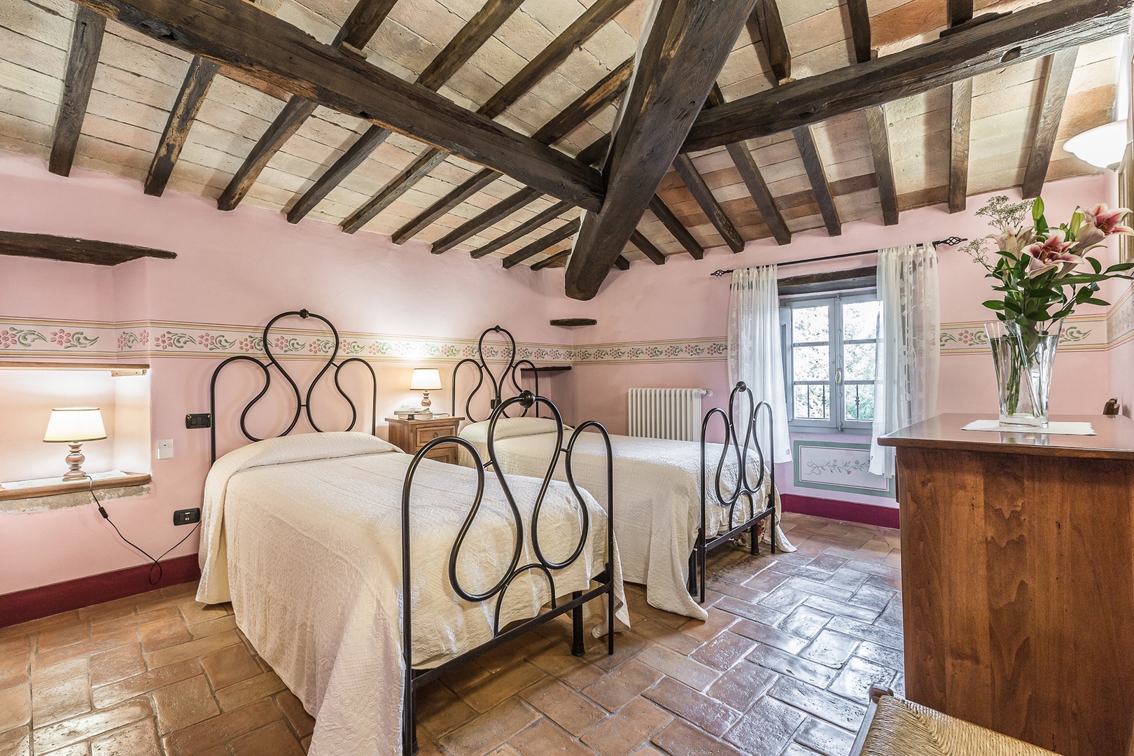 Bedroom 1 classic Tuscan style with calm colors. Note the fine beams and cotto floor.