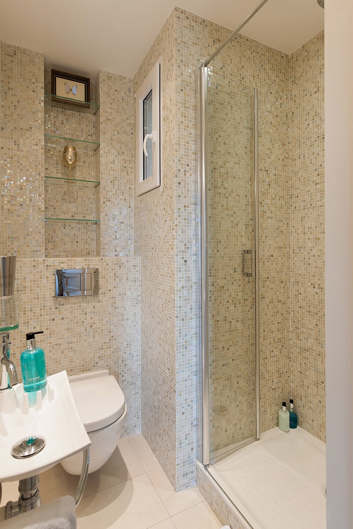 Bathroom 2 is decorated with iridescent glass tiles.