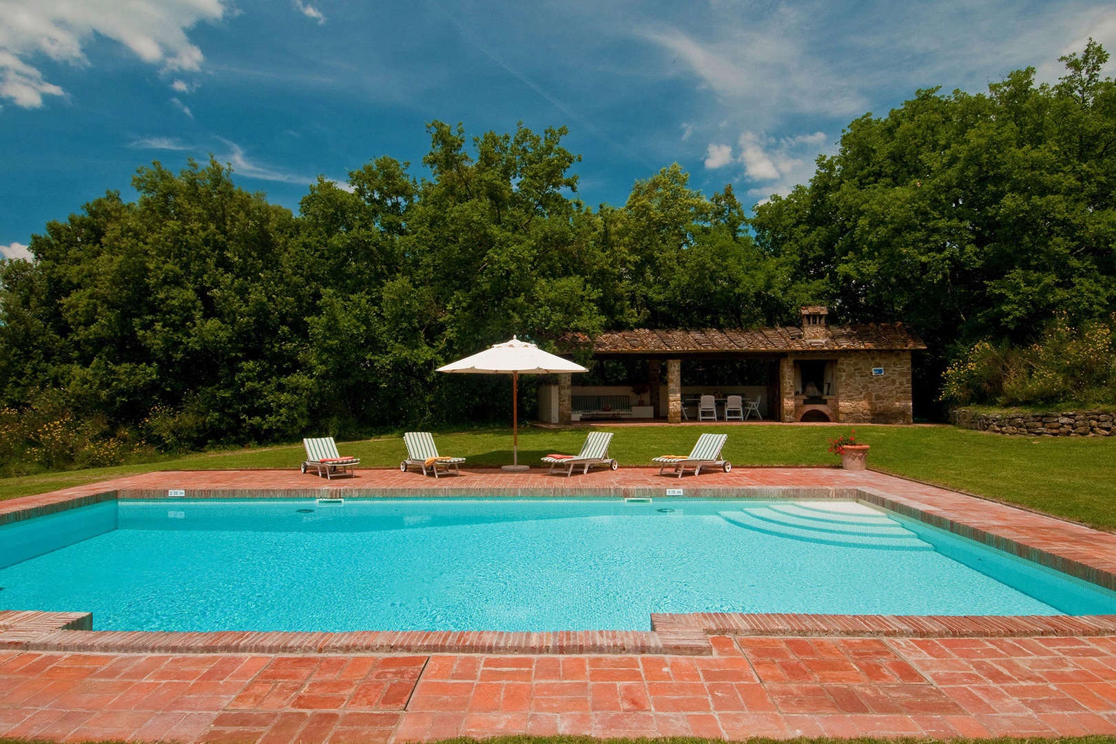 Sparking blue pool surrounded by greenery and vistas awaits you at L'Albero Bello.