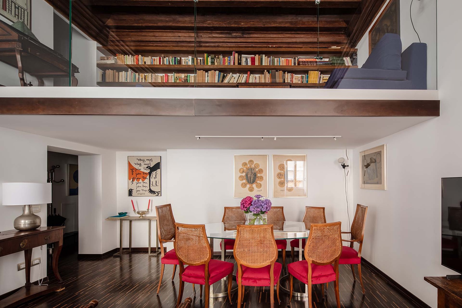 A lofted sitting area with library is located above the dining area.