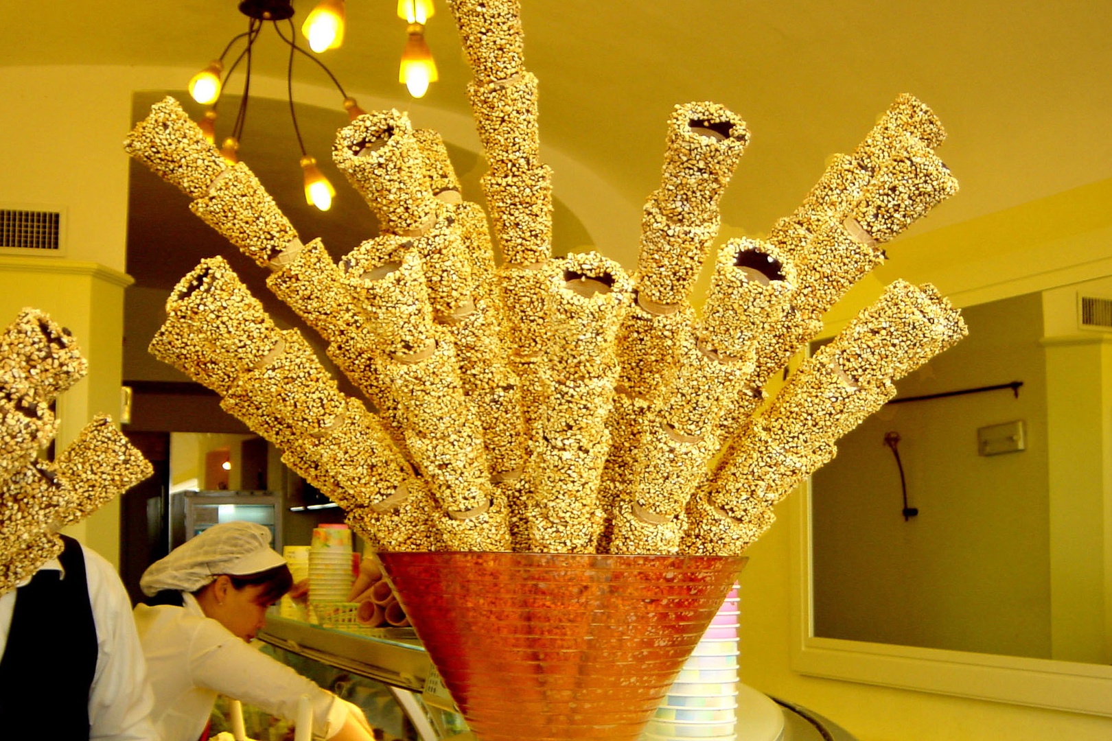 Ice cream cones covered with chocolate and crushed nuts await delicious Gelato.