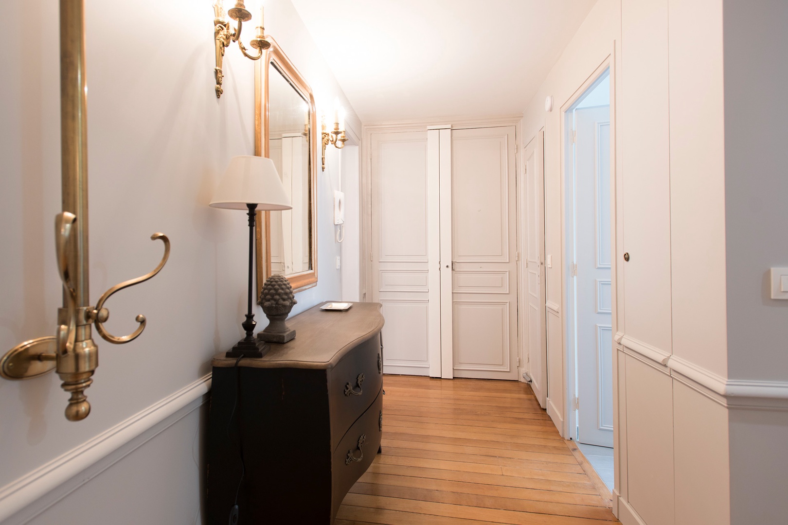 Wall sconces illuminate the hallway.