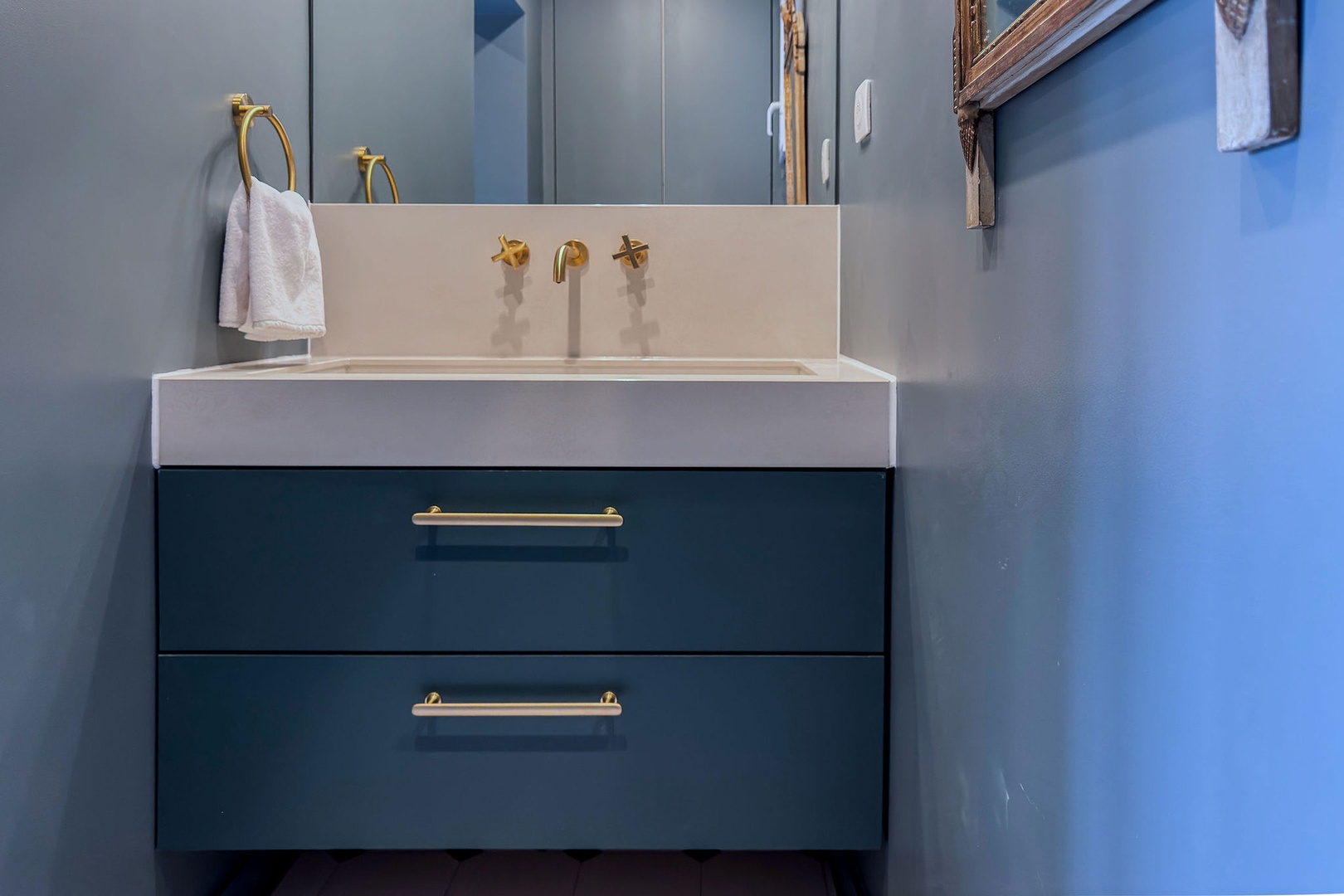 Below sink storage in en suite bathroom.