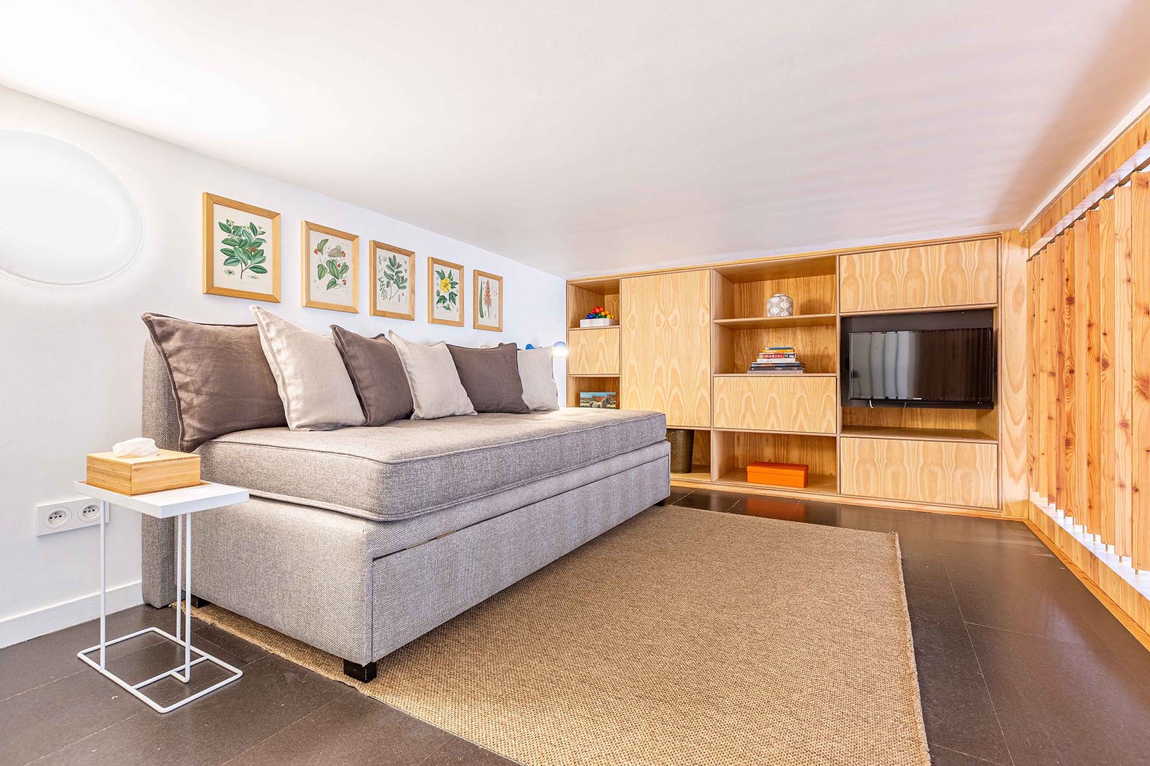 Mezzanine living area has a sofa and TV.