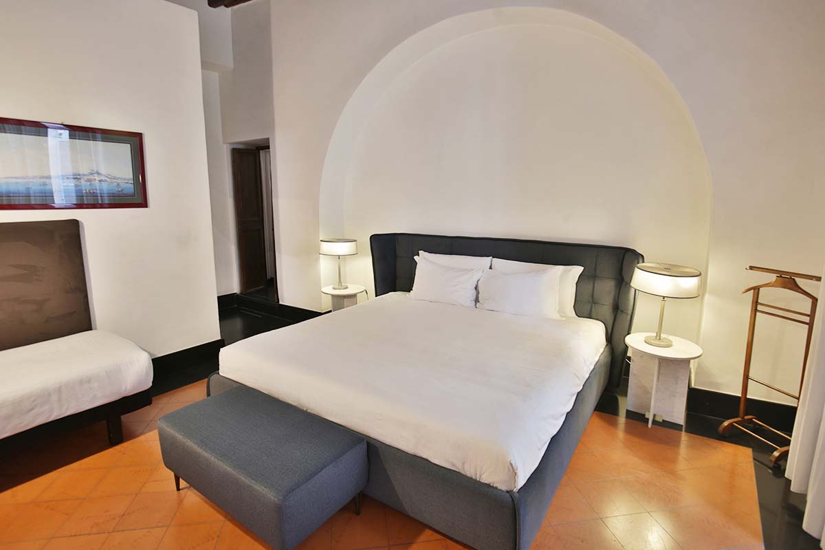 Your private sanctuary features a plush king bed beneath a stunning arched alcove, complemented by elegant seating and modern lighting.