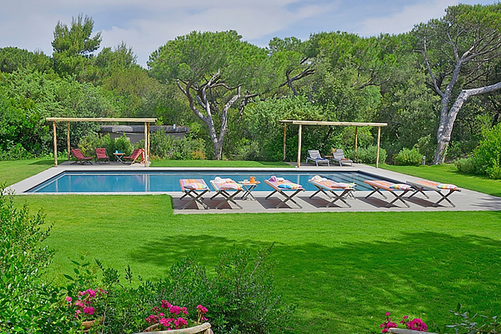 The tranquil pool is surrounded by a wooden deck and bamboo covers for shade.