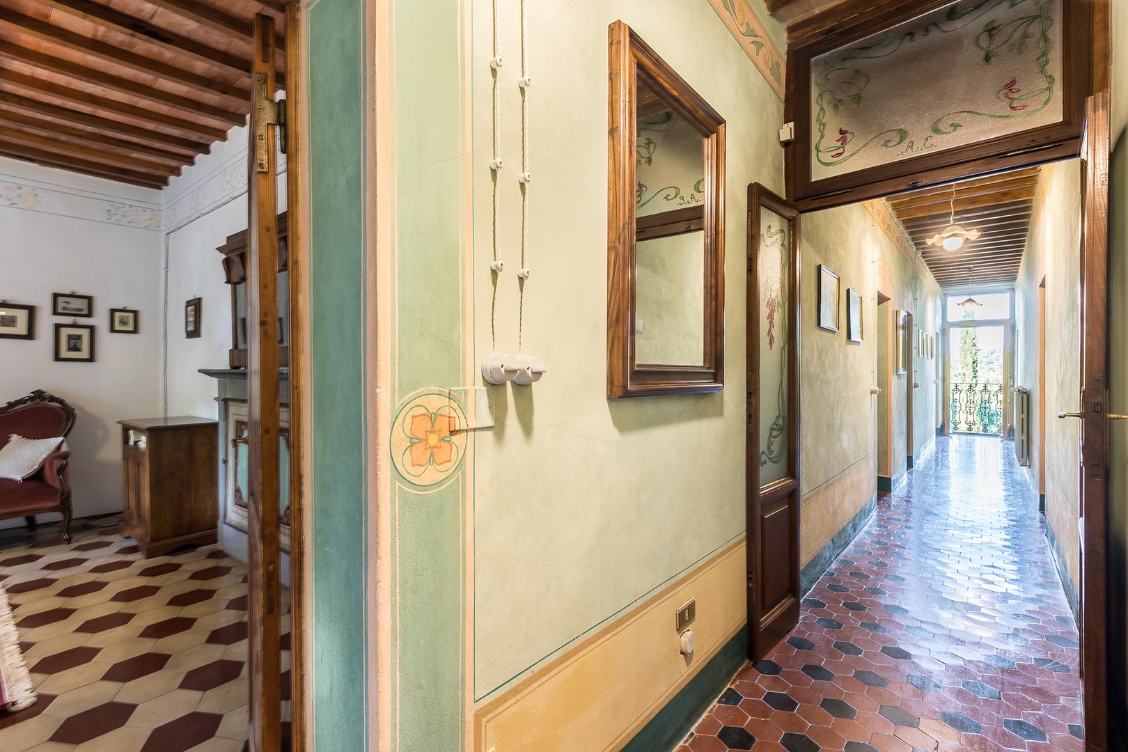 Tiled hallway on the 2nd floor with a French balcony door at the end with beautiful views.