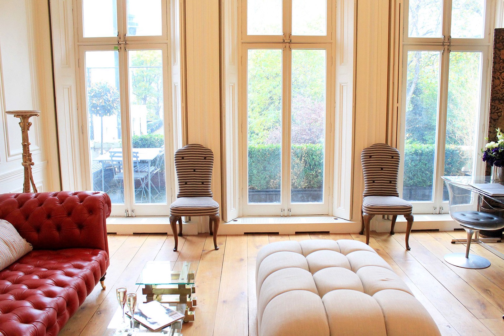 Large French doors open to an inviting balcony with table and chairs