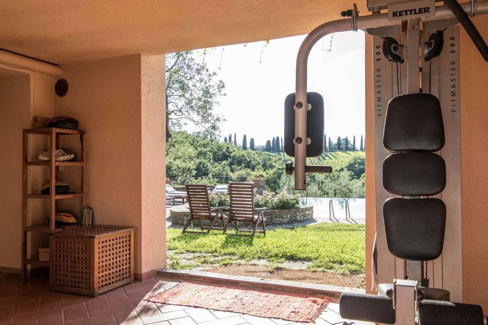 Fitness area with gym and bathroom near the pool.