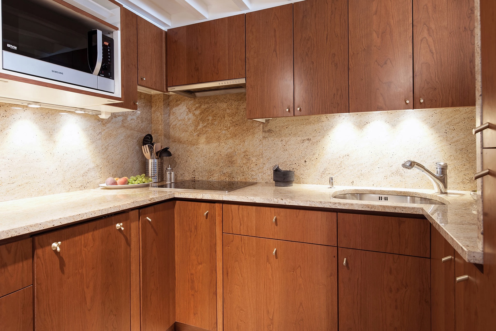 The fully-equipped kitchen is covered in marble and rich hardwood.