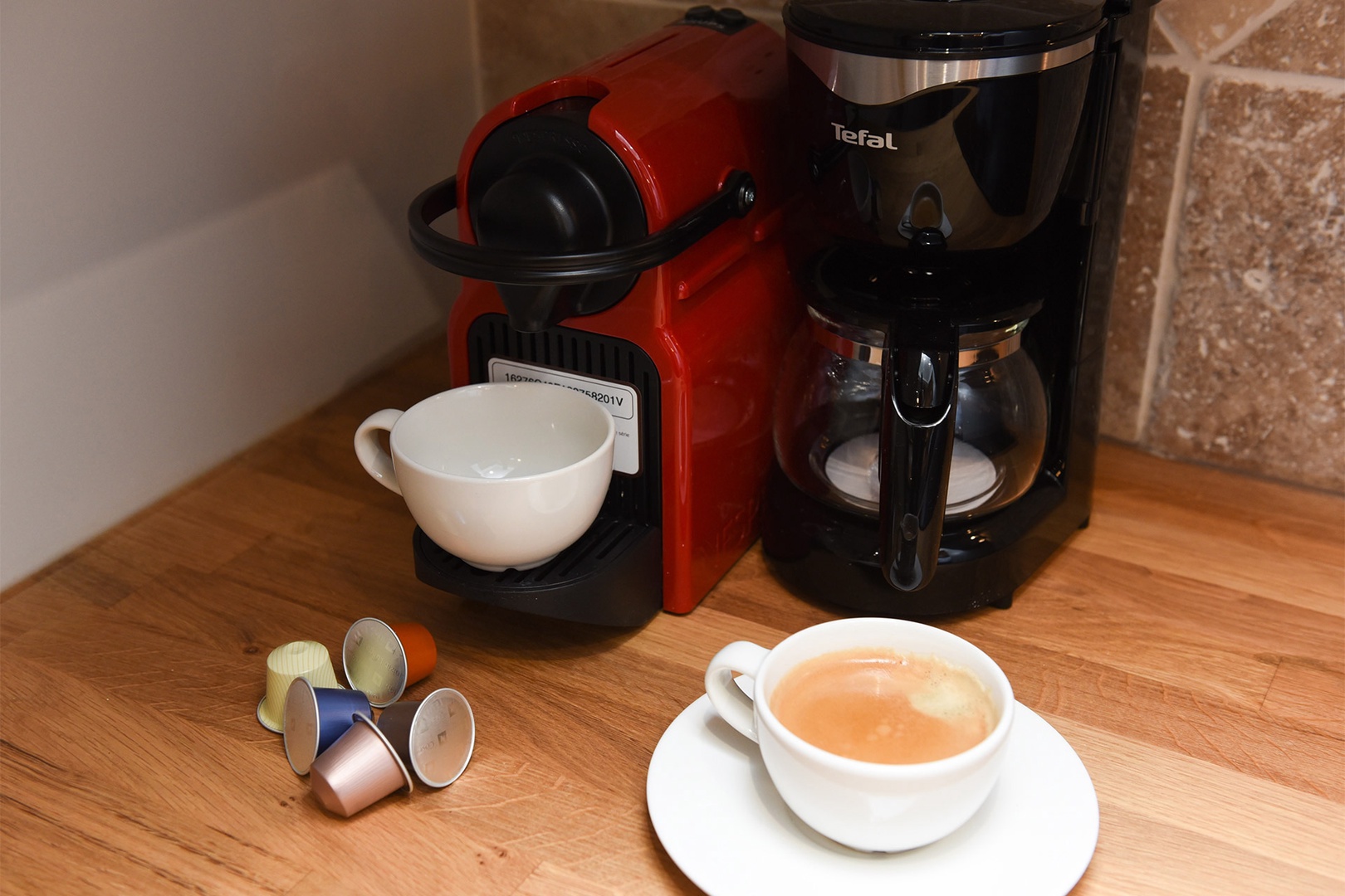 The kitchen is stocked with a Nespresso maker and capsules.