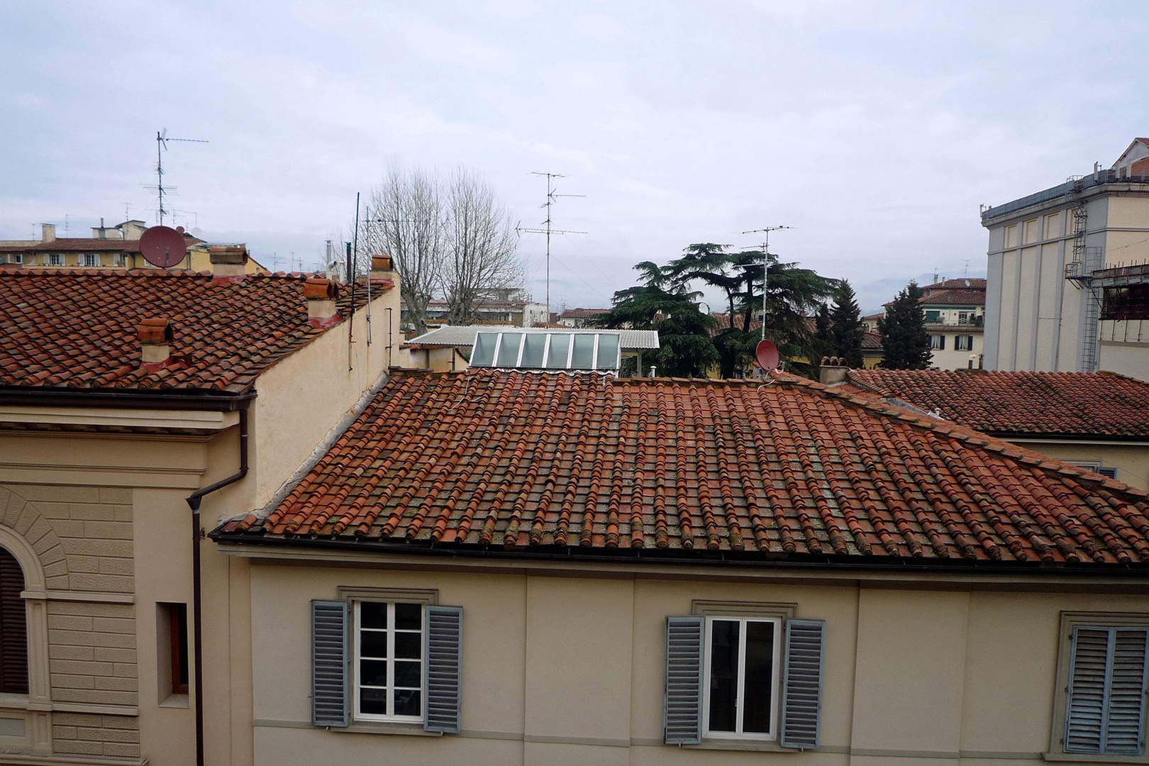 Pleasant views from the living room window of rooftops and trees in the distance.