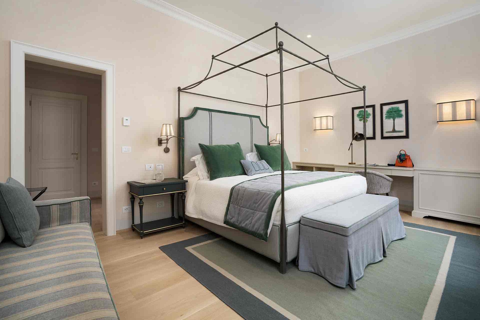 Unwind in your elegant bedroom 2 retreat, where a dramatic canopy bed with plush green accents awaits your arrival.