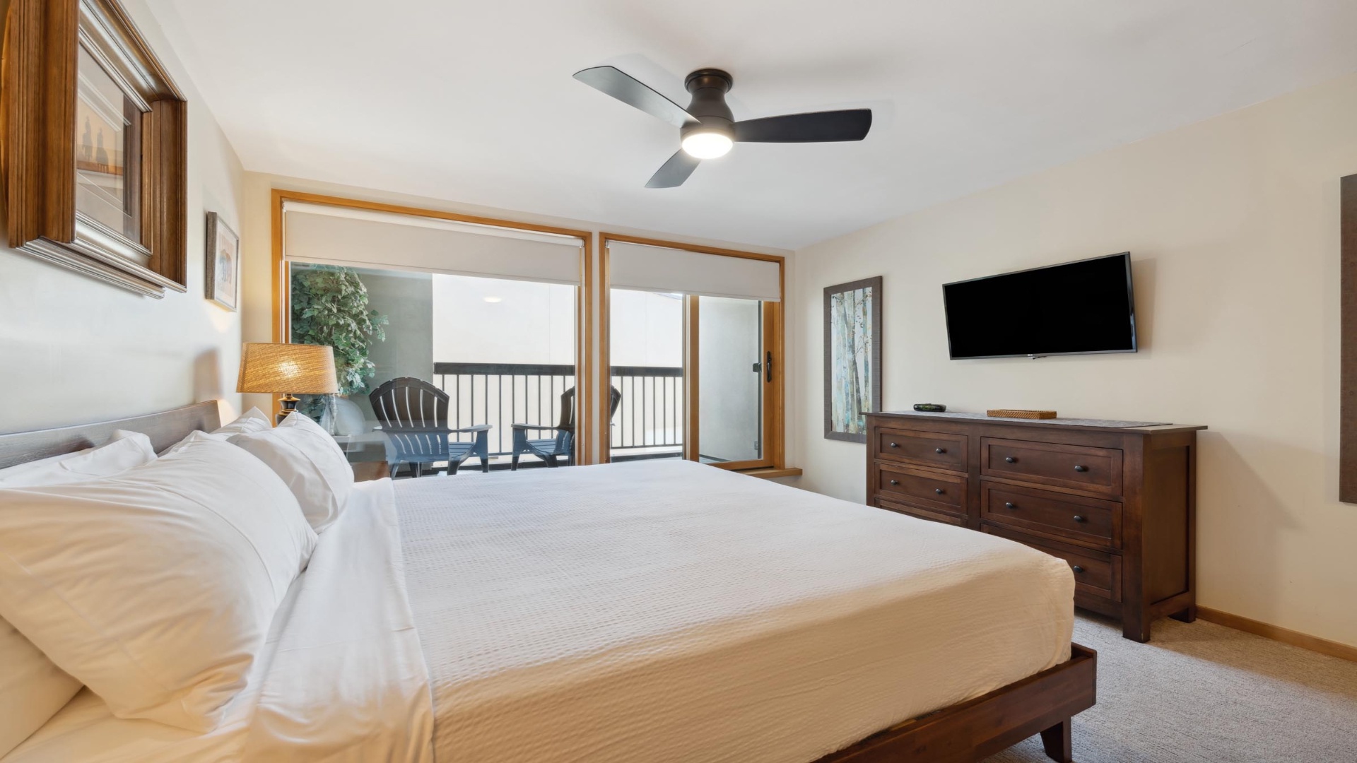Unwind in your serene bedroom where crisp linens and a ceiling fan promise restful sleep. Step onto your private balcony to soak in the peaceful views.