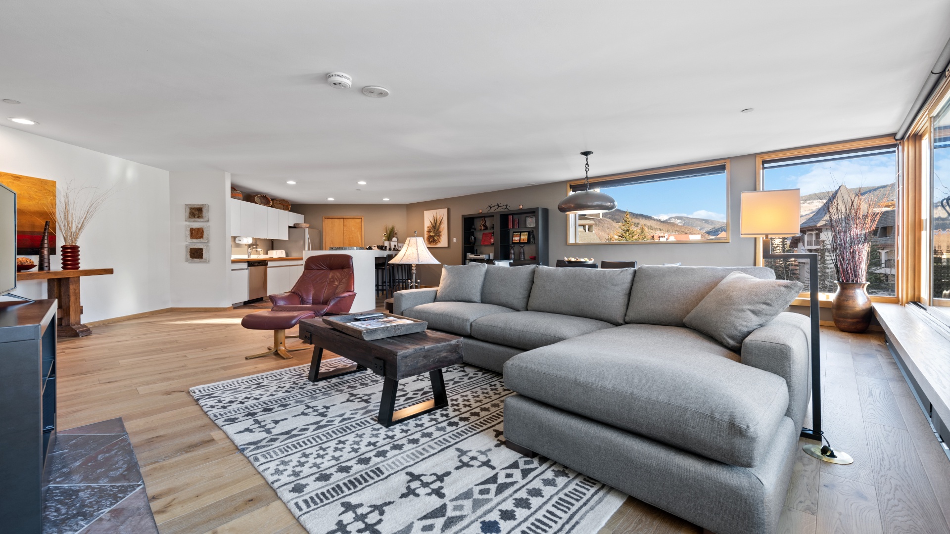 Unwind on the spacious sectional with stunning mountain views framing your retreat. Warm wood floors and an open layout invite you to relax and feel at home.