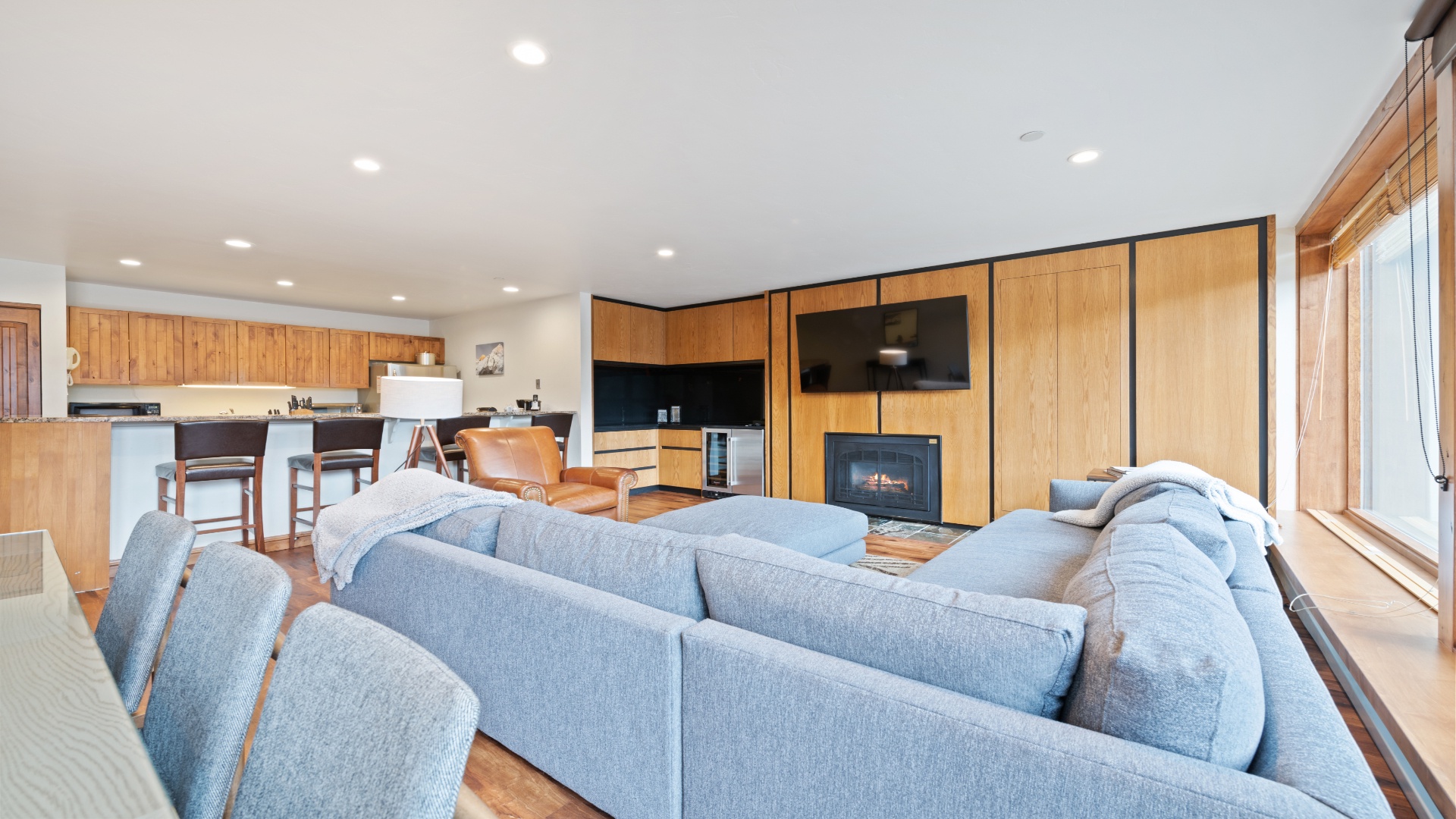 Settle into this bright, open-plan space where modern comforts meet warm wood tones. Relax on plush seating, enjoy cozy evenings by the fireplace, and whip up meals in your fully-equipped kitchen.