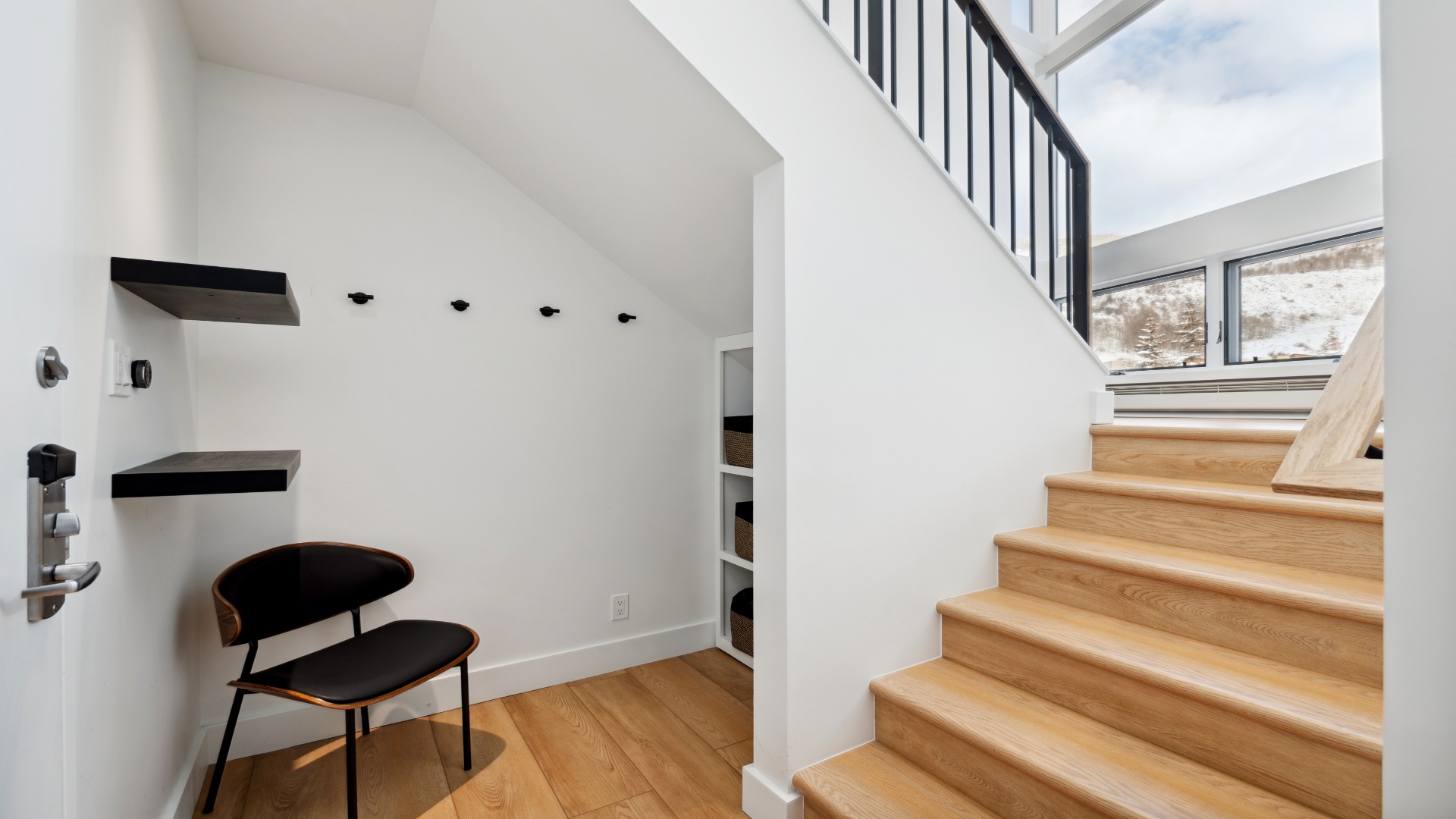 Warm wooden stairs lead you to bright upper levels, while a cozy nook offers a quiet spot to relax and plan your day.