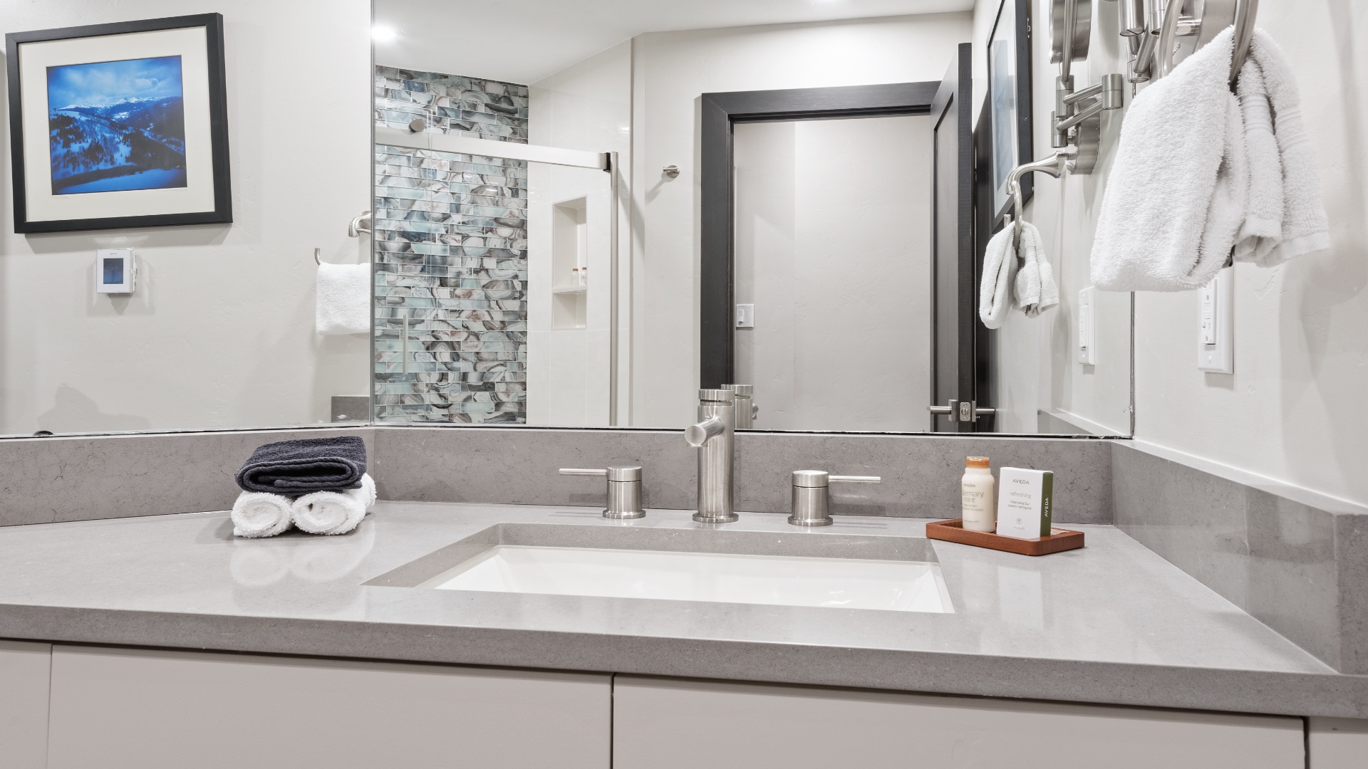 Your modern bathroom features a sleek vanity with fresh towels and premium toiletries waiting for you. Unwind in the stylish space with contemporary finishes and thoughtful amenities designed for your comfort.