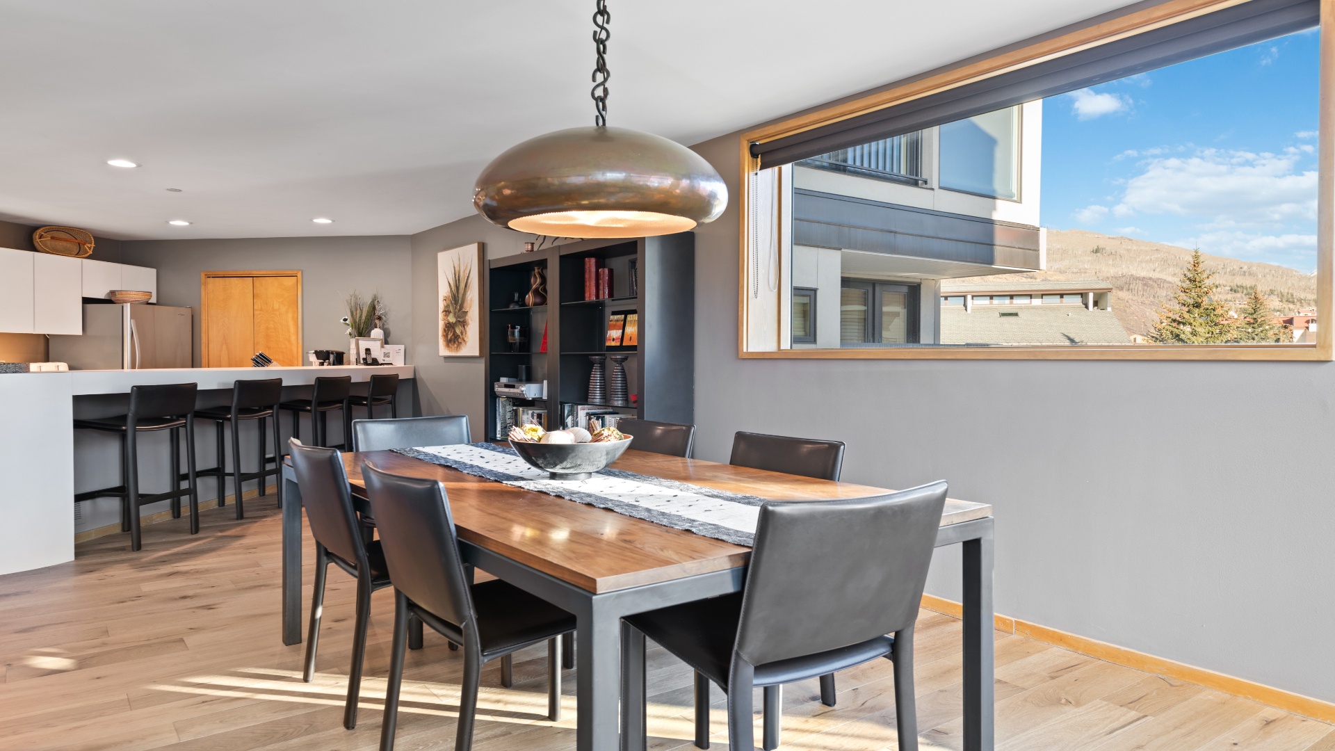 Gather around this stunning dining table with mountain views through expansive windows, where meals become memorable moments in your mountain retreat.