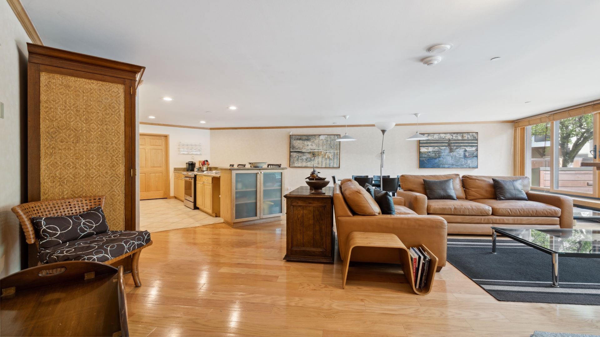 Unwind in your spacious open-plan living area with warm wood floors, plush leather seating, and a fully equipped kitchen—perfect for relaxing after a day exploring the area.