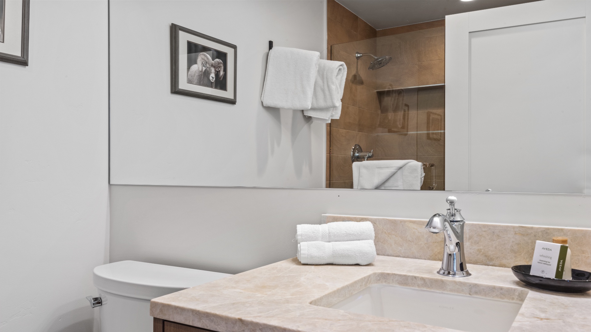 Refresh in your private bathroom with warm tones and soft lighting. Fluffy towels, a sleek stone vanity, and a spacious walk-in shower await your arrival.