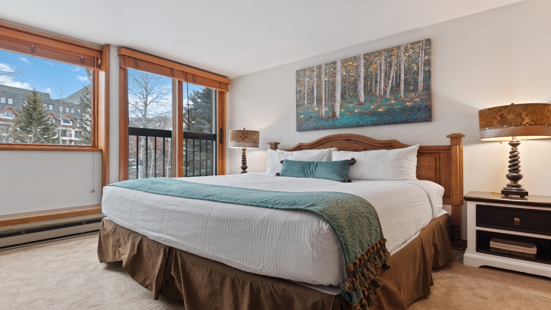 Unwind in your tranquil bedroom with plush bedding and art-filled walls. Large windows frame mountain views, while warm wood tones create a cozy retreat for restful nights.