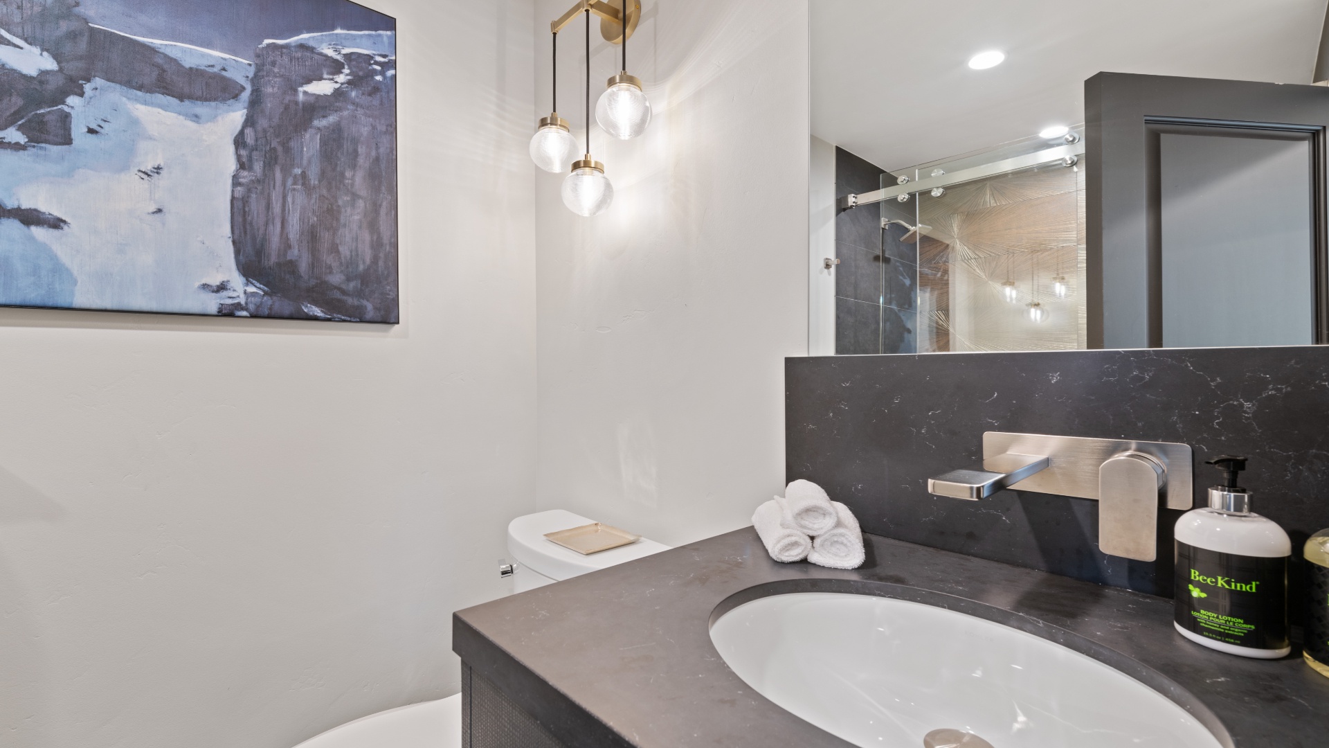 Your private bathroom features modern fixtures, a sleek vanity with fresh towels, and contemporary lighting—perfectly appointed for your comfort and convenience.
