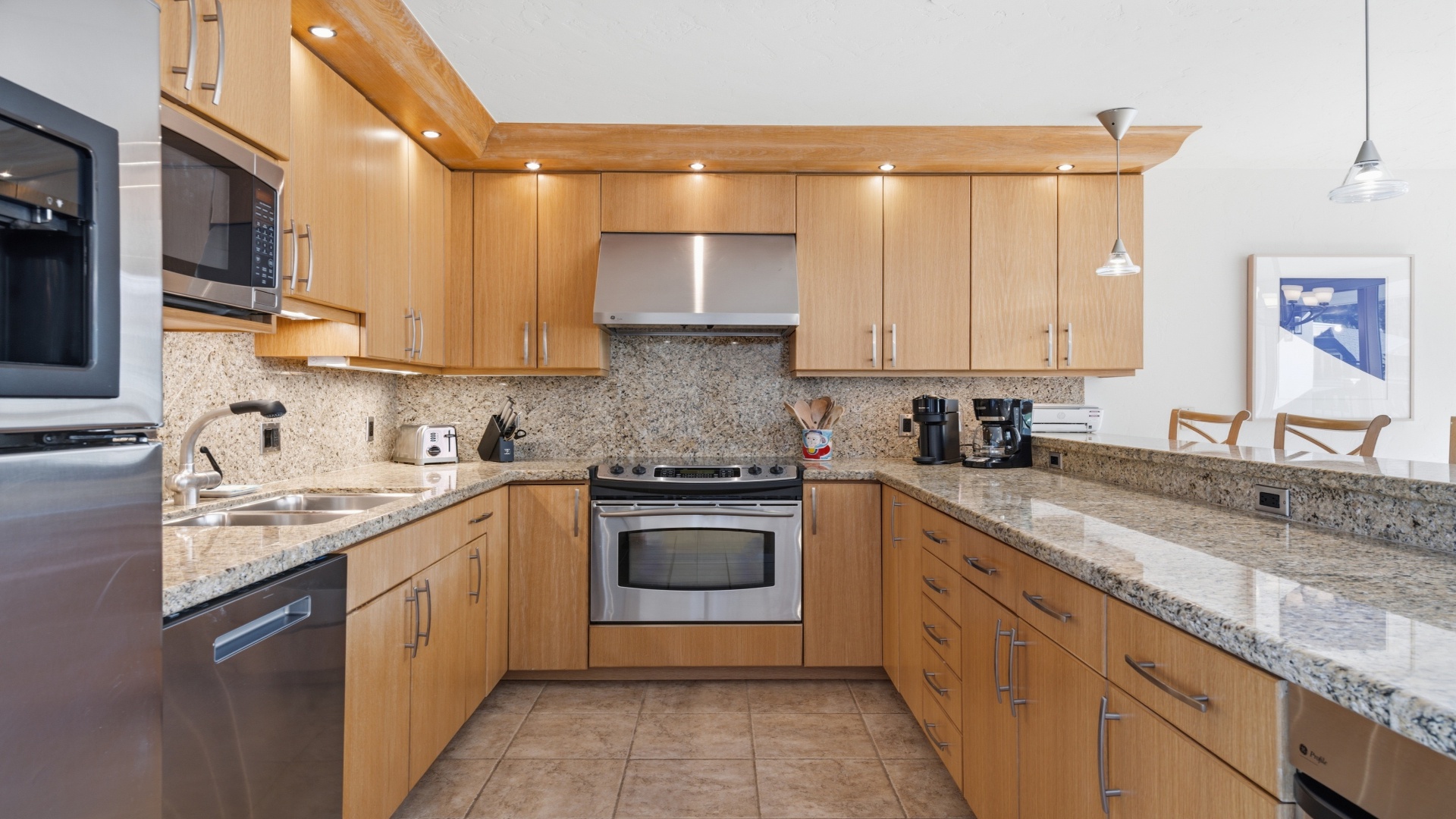 Your fully equipped kitchen features granite countertops, stainless steel appliances, and warm wood cabinetry—perfect for preparing homemade meals or brewing your morning coffee in style.