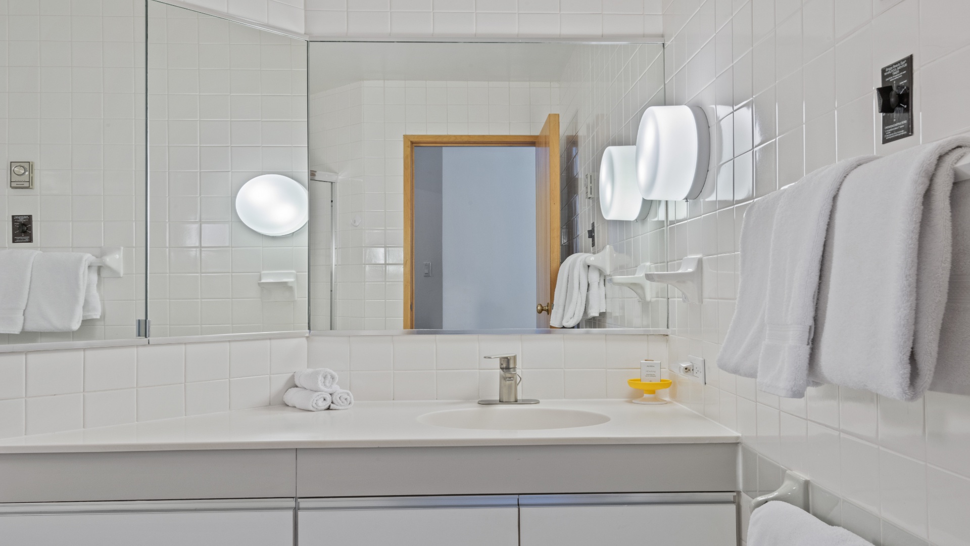 Your private bathroom features clean white subway tile, a walk-in shower, and plush towels ready for you. A bright, serene space to refresh after your adventures.