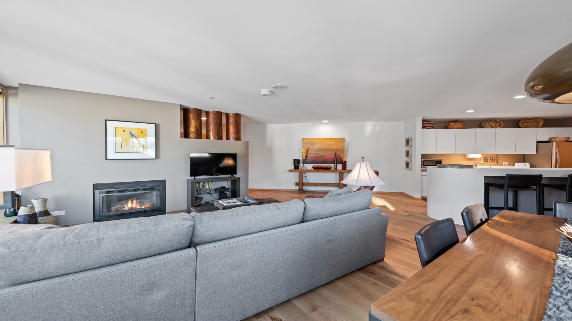 Your open-concept living area blends warmth and style, where you can unwind by the sleek fireplace, share meals at the rich wood table, and enjoy modern comforts in a light-filled space.