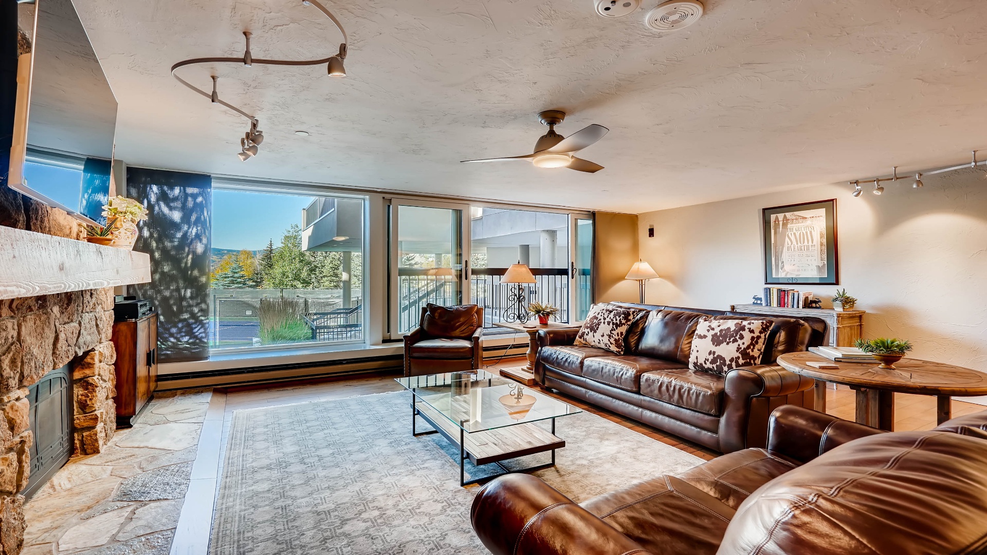 Sink into plush leather sofas by the fireplace and let natural light fill your space through floor-to-ceiling windows. Your perfect retreat awaits with modern comfort and mountain views.