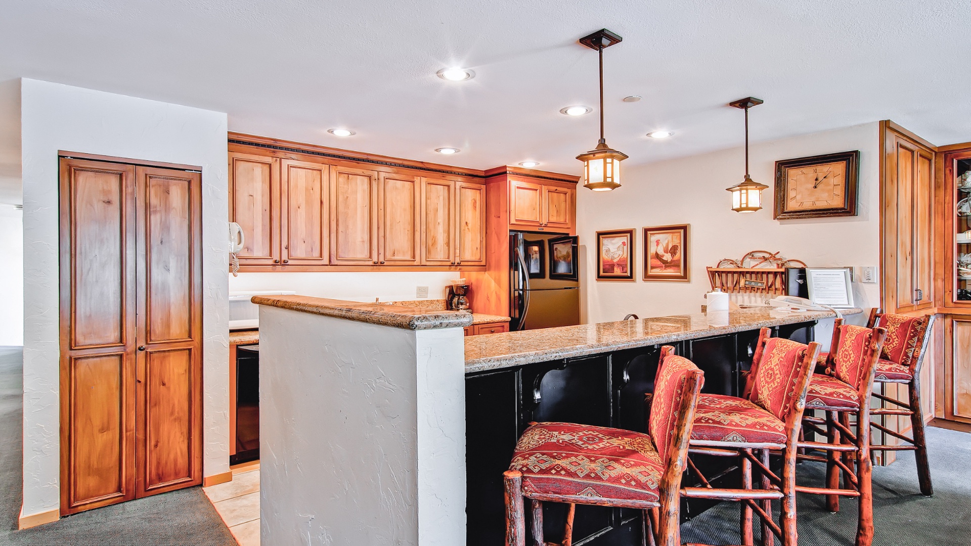 Your spacious kitchen features rich wood cabinetry, granite countertops, and a breakfast bar with seating—perfect for preparing meals and gathering with loved ones over morning coffee.