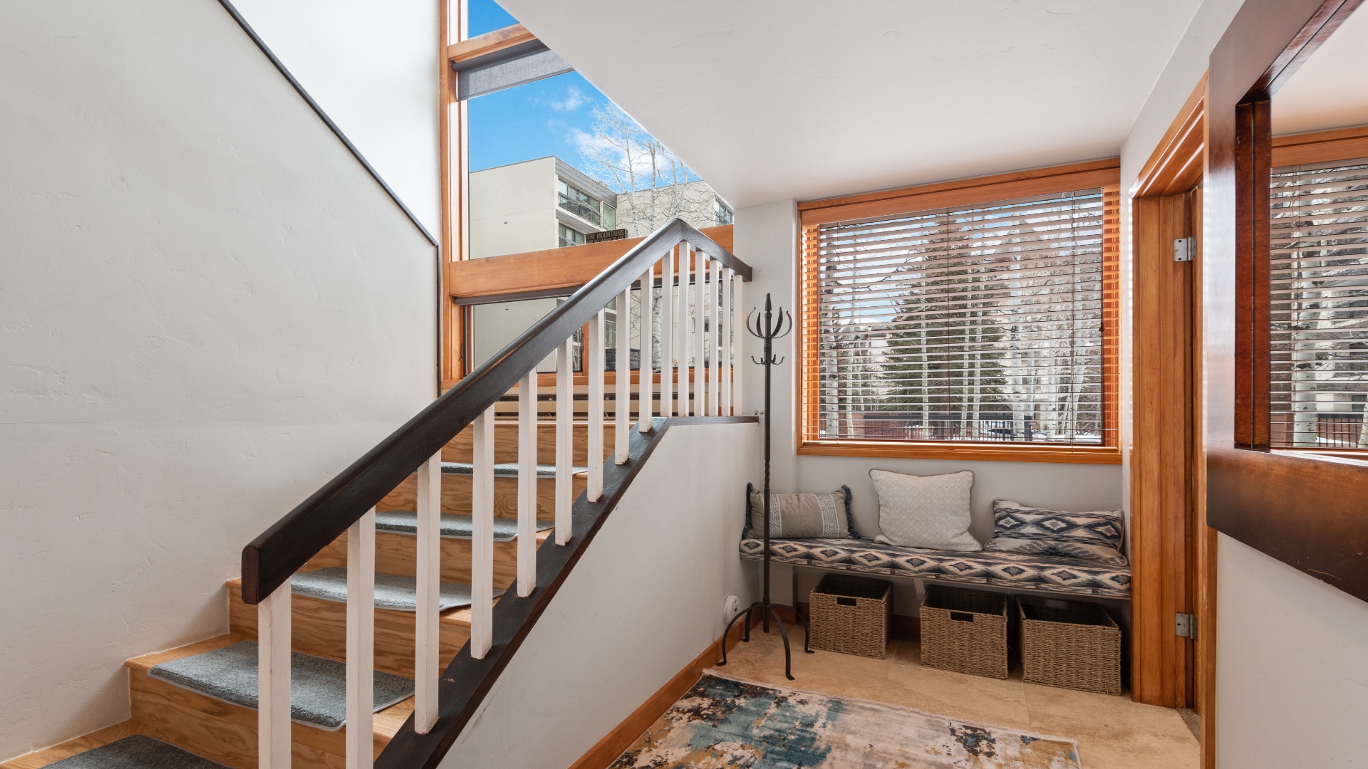 Your welcoming entry features warm wood accents and natural light streaming through a skylight, creating an inviting atmosphere as you step inside your mountain retreat.
