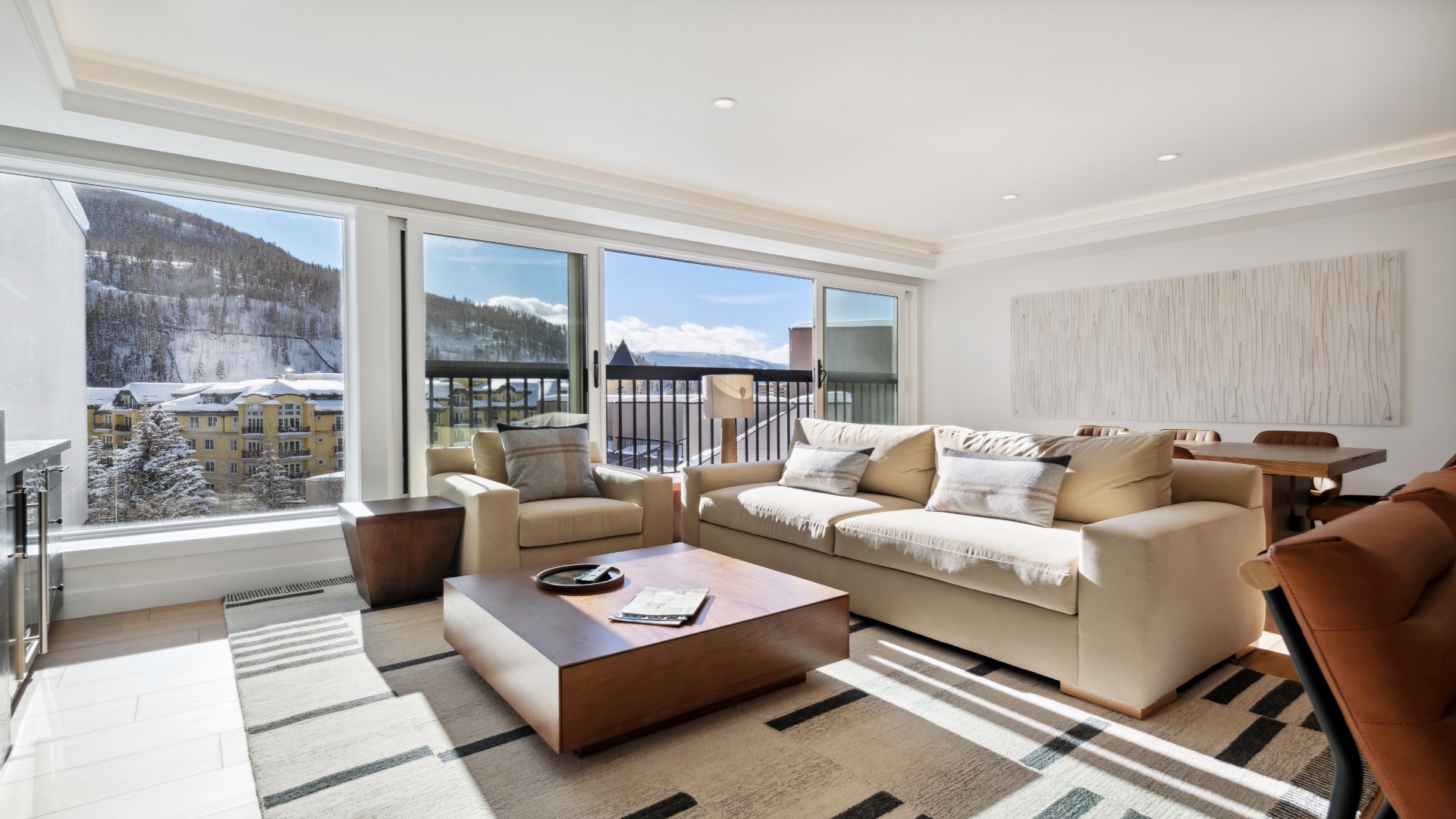 Sink into plush seating as you gaze out at snow-dusted peaks through expansive windows, where mountain tranquility meets refined comfort in your private retreat.