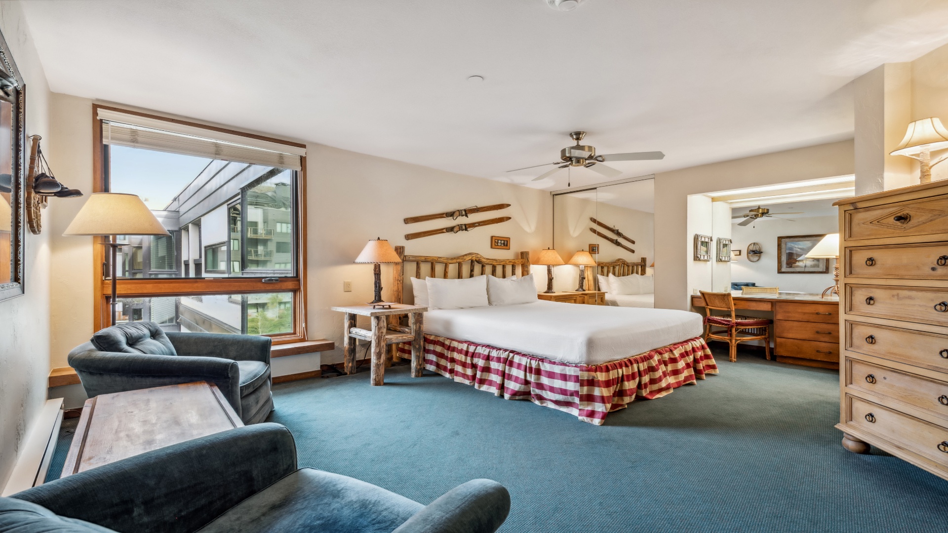 Sink into your cozy queen beds with rustic log frames after a day of adventure. Large windows bring natural light, while plush seating invites you to unwind in your spacious mountain retreat.