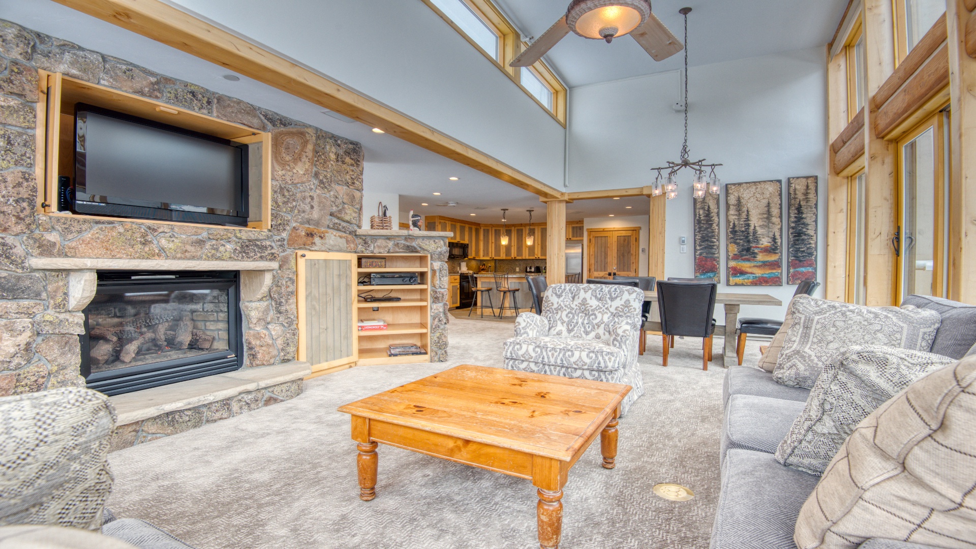 Unwind in your spacious open-concept retreat, where rustic stone walls, soaring ceilings, and cozy fireside seating invite you to relax and connect with mountain charm and modern comfort.