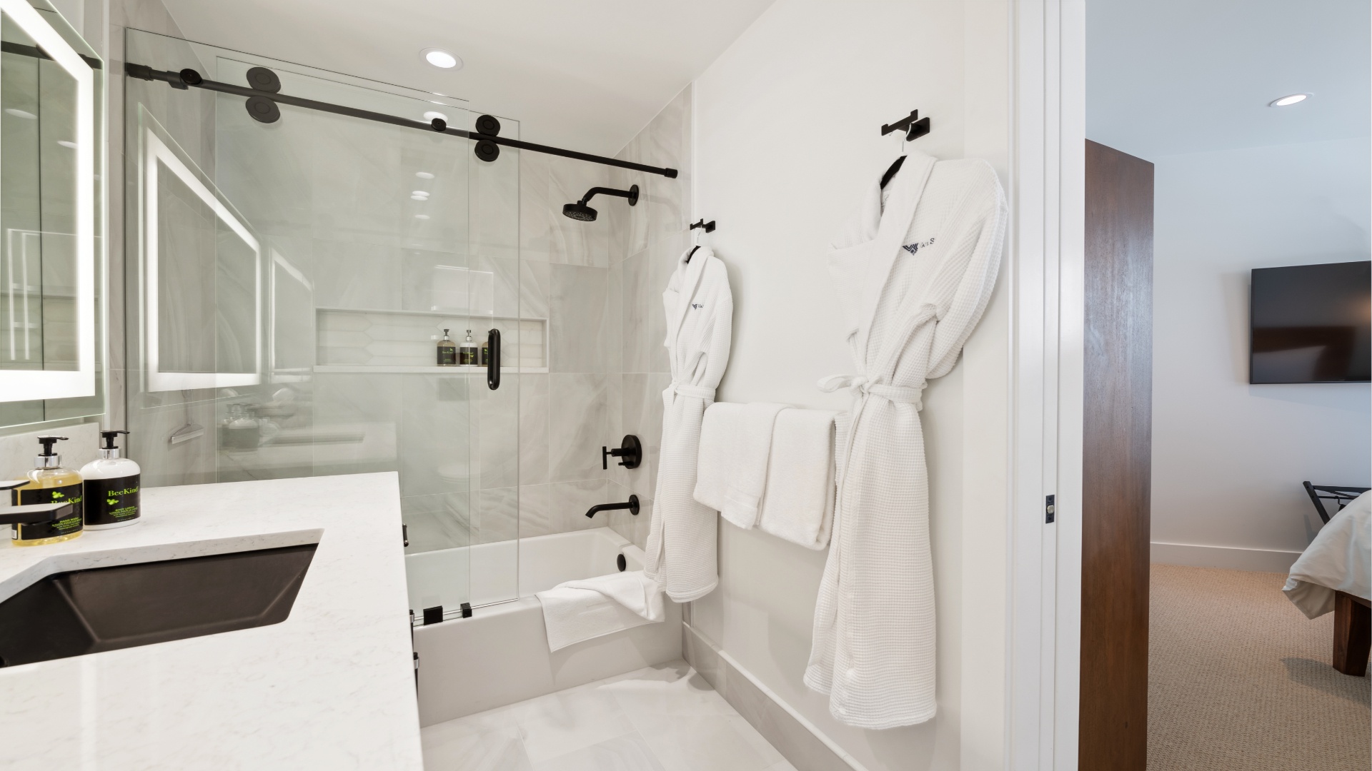 Slip into your plush robe after a soak in the tub or refresh under the sleek walk-in shower with matte-black fixtures and spa-inspired finishes.