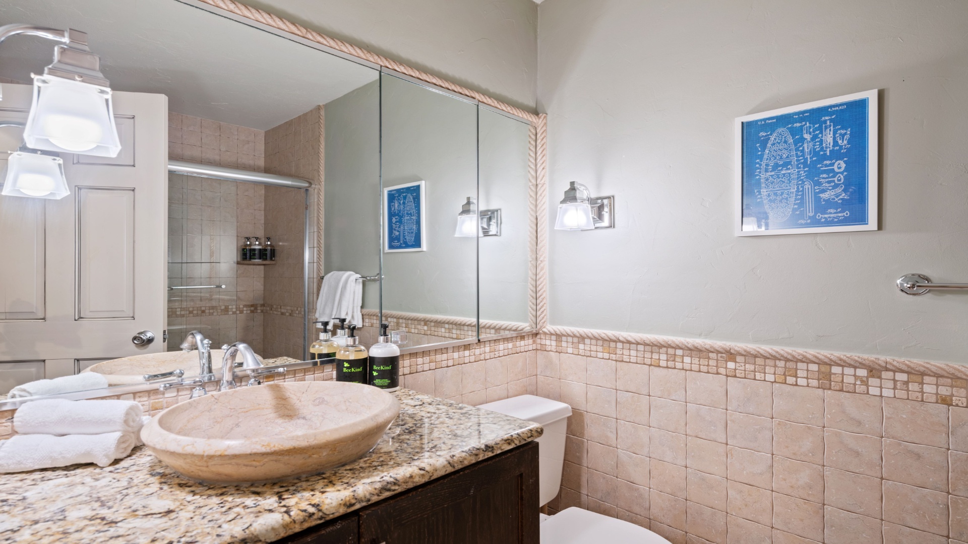 Your private bathroom features a travertine vessel sink on granite countertops, with fresh towels and thoughtful amenities awaiting your arrival.