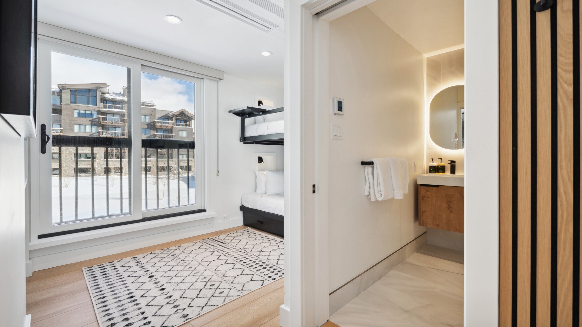 Bright, modern room with your own balcony and city views. Step into the sleek en-suite bathroom, where warm lighting and clean lines welcome you after a day exploring.