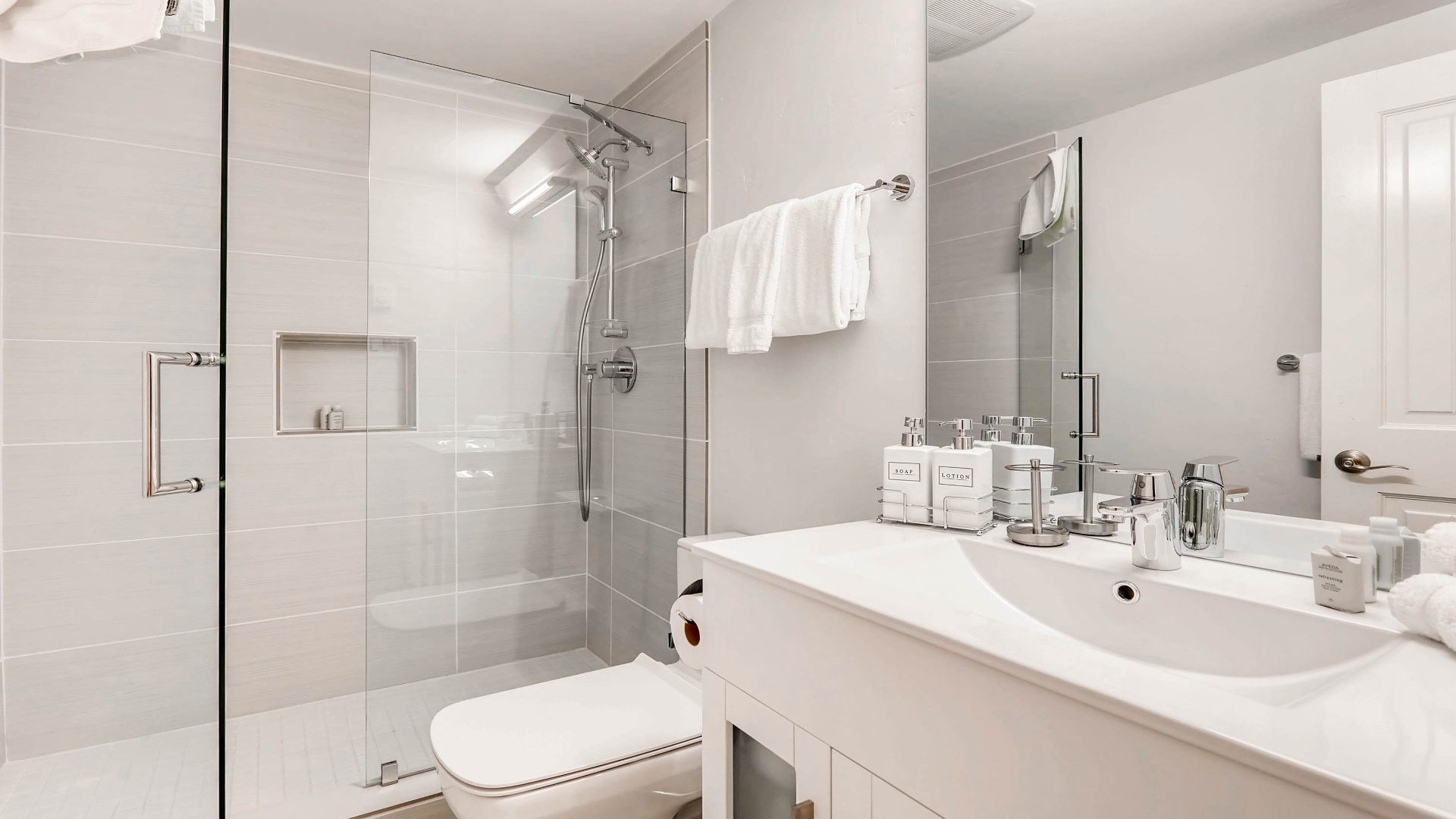 Freshen up in your pristine bathroom featuring a luxurious walk-in shower, plush towels, and spa-like amenities ready for your arrival.
