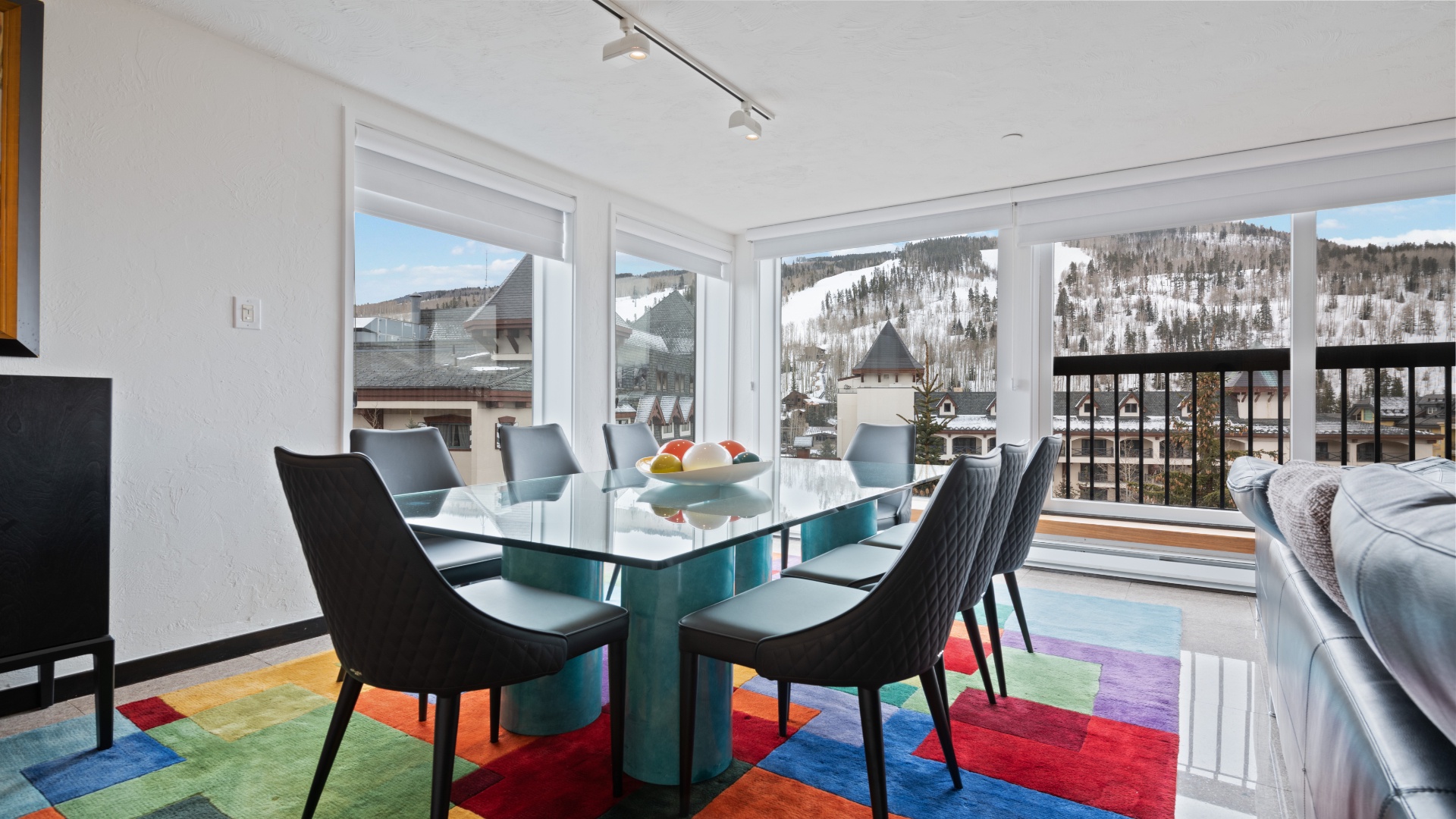 Gather around this stylish dining table while soaking in stunning mountain and village views through expansive windows—your perfect spot for memorable meals and morning coffee.