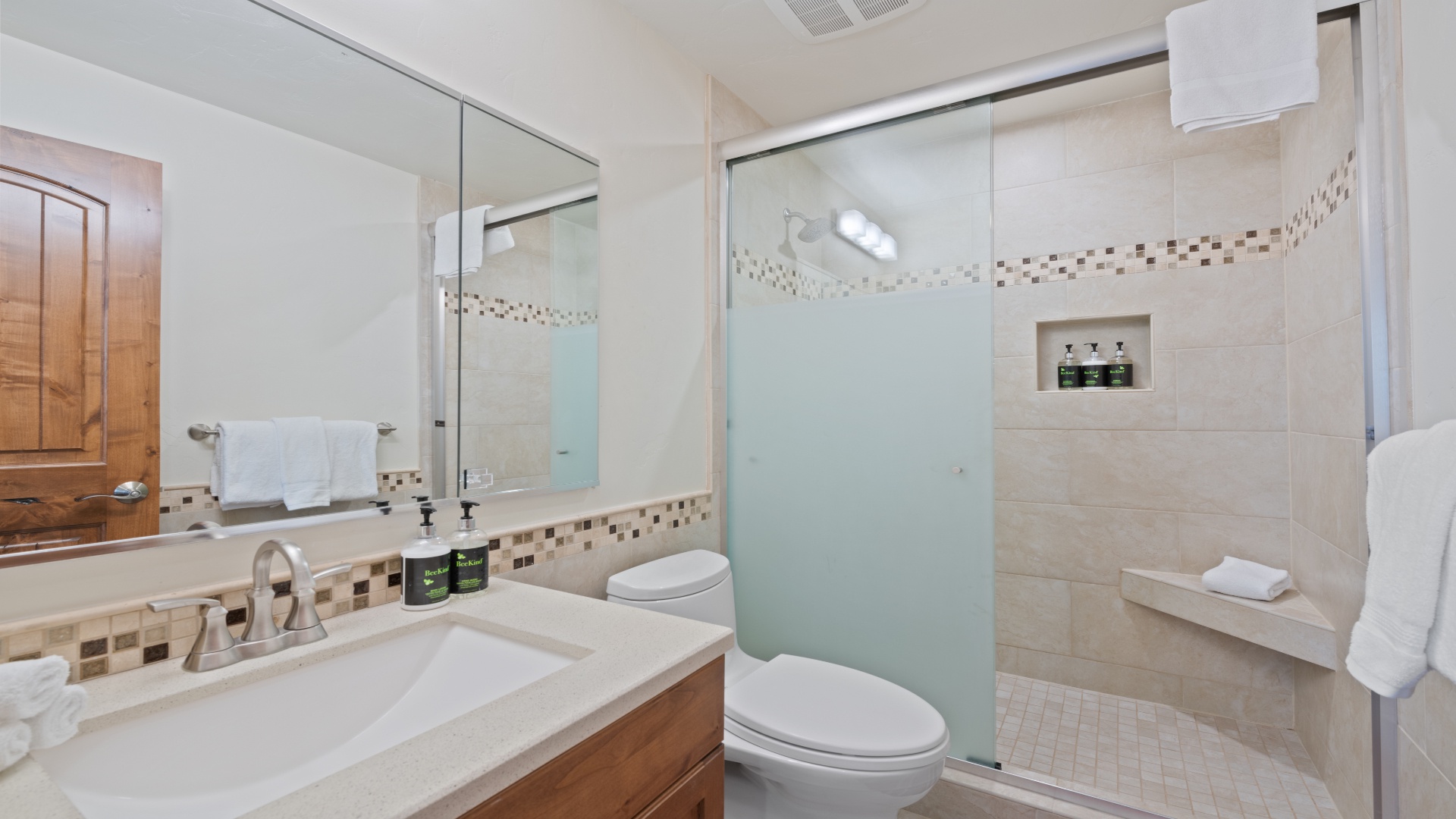 Step into your beautifully appointed bathroom, where neutral tones and mosaic tile accents create a soothing retreat. Fresh towels, premium toiletries, and a spacious walk-in shower await you.